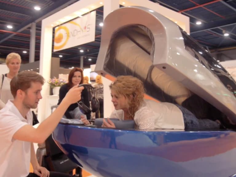 A guest experiencing the SpaCapsule — a hydro massage capsule that provides a 4-minute multisensory relaxation experience at events.