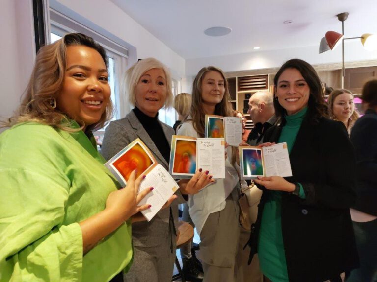A guest sitting for an aura photography session at a corporate event with a colorful aura portrait.